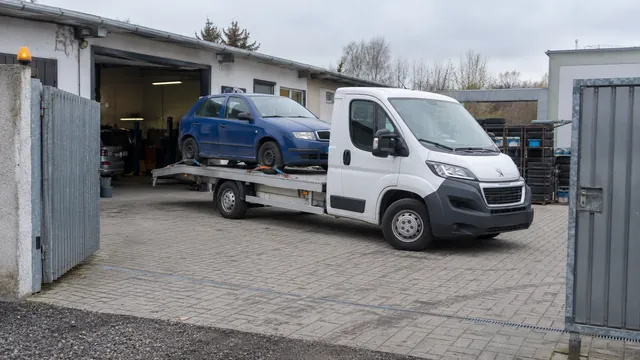 Bílý odtahový vůz s upevněným vozidlem Škoda na hliníkové plošině