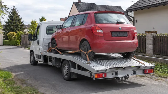 Bílý odtahový vůz s upevněným vozidlem Škoda na hliníkové plošině
