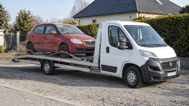 Bílý odtahový vůz s upevněným vozidlem Škoda na hliníkové plošině