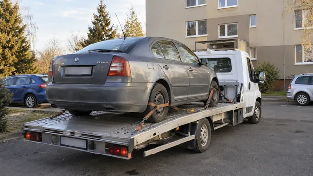 Bílý odtahový vůz s upevněným vozidlem Škoda na hliníkové plošině