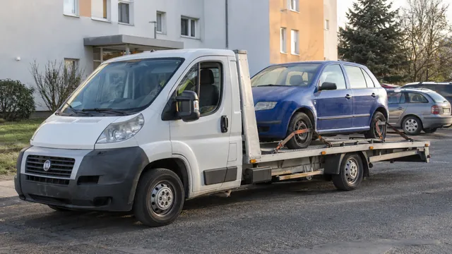 Bílý odtahový vůz s upevněným vozidlem Škoda na hliníkové plošině