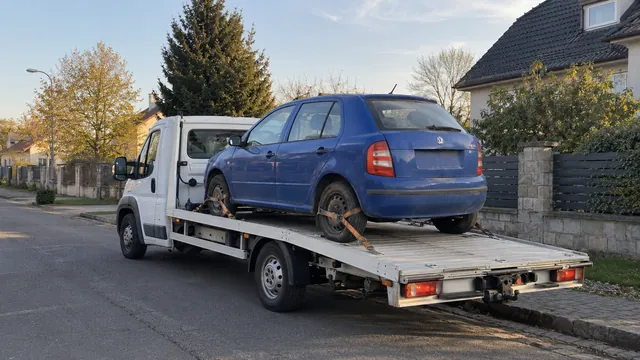 Bílý odtahový vůz s upevněným vozidlem Škoda na hliníkové plošině