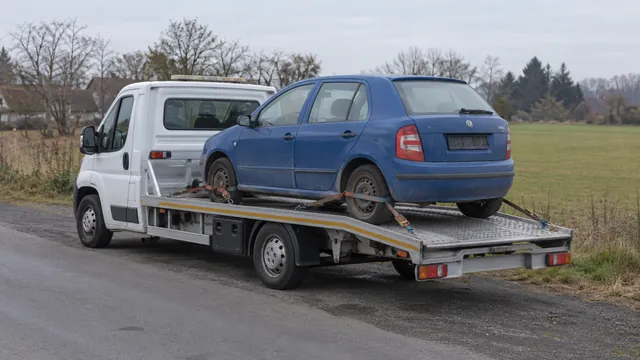 Bílý odtahový vůz s upevněným vozidlem Škoda na hliníkové plošině