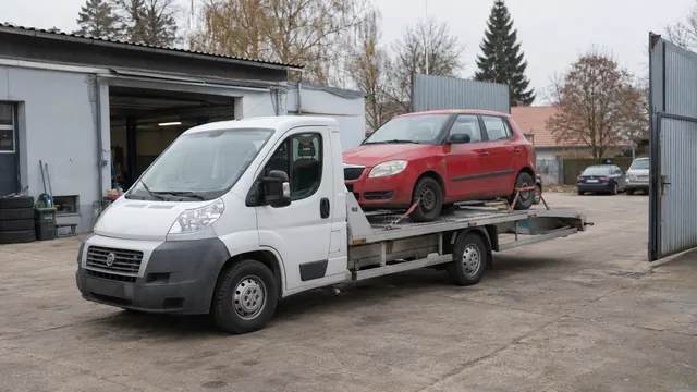 Bílý odtahový vůz s upevněným vozidlem Škoda na hliníkové plošině