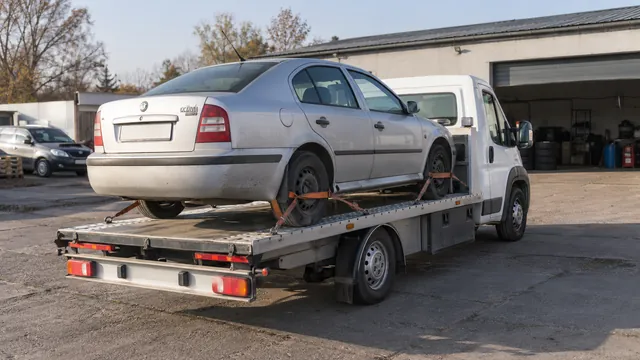 Bílý odtahový vůz s upevněným vozidlem Škoda na hliníkové plošině