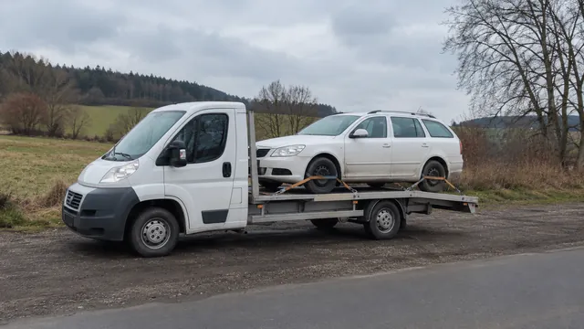 Bílý odtahový vůz s upevněným vozidlem Škoda na hliníkové plošině