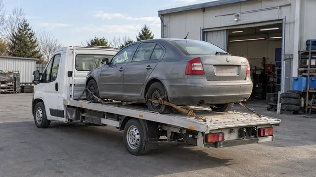 Bílý odtahový vůz s upevněným vozidlem Škoda na hliníkové plošině