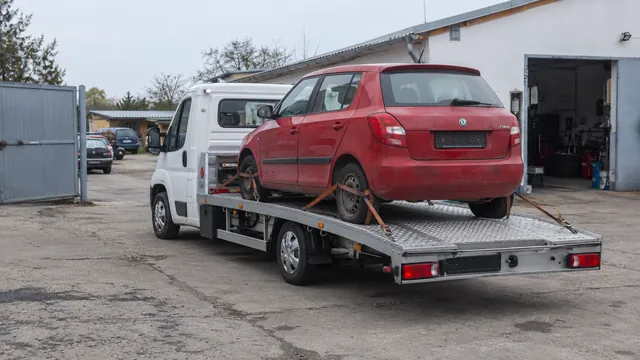 Bílý odtahový vůz s upevněným vozidlem Škoda na hliníkové plošině