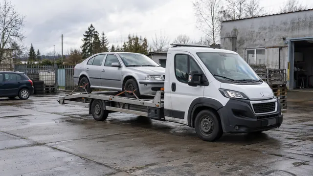 Bílý odtahový vůz s upevněným vozidlem Škoda na hliníkové plošině