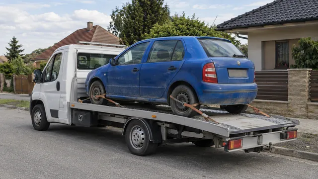 Bílý odtahový vůz s upevněným vozidlem Škoda na hliníkové plošině