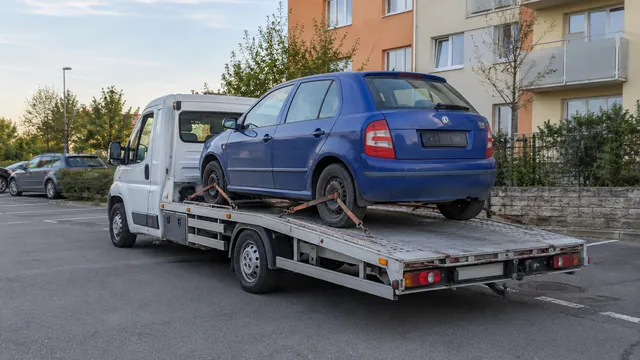 Bílý odtahový vůz s upevněným vozidlem Škoda na hliníkové plošině