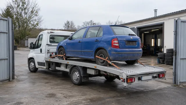 Bílý odtahový vůz s upevněným vozidlem Škoda na hliníkové plošině
