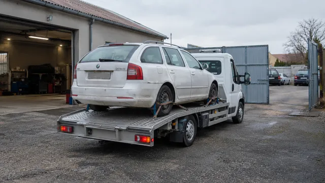 Bílý odtahový vůz s upevněným vozidlem Škoda na hliníkové plošině