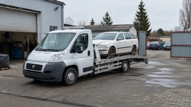 Bílý odtahový vůz s upevněným vozidlem Škoda na hliníkové plošině