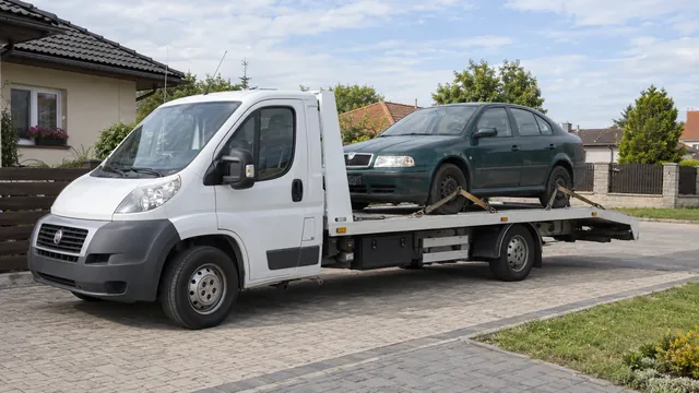 Bílý odtahový vůz s upevněným vozidlem Škoda na hliníkové plošině