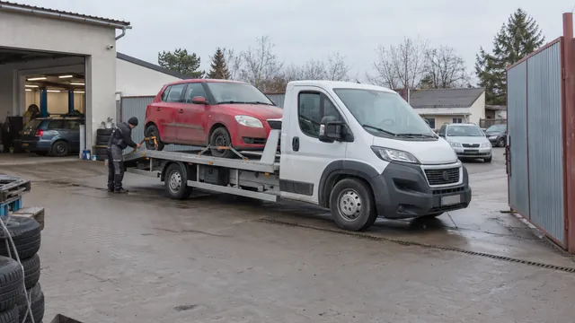 Bílý odtahový vůz s upevněným vozidlem Škoda na hliníkové plošině