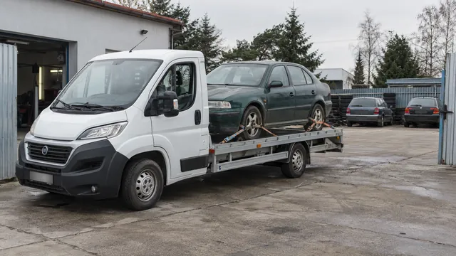 Bílý odtahový vůz s upevněným vozidlem Škoda na hliníkové plošině