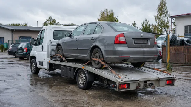 Bílý odtahový vůz s upevněným vozidlem Škoda na hliníkové plošině