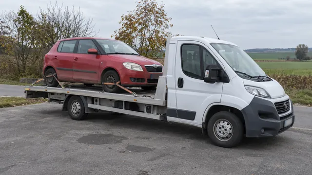 Bílý odtahový vůz s upevněným vozidlem Škoda na hliníkové plošině