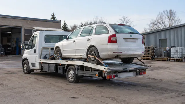 Bílý odtahový vůz s upevněným vozidlem Škoda na hliníkové plošině