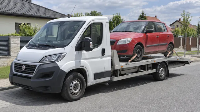 Bílý odtahový vůz s upevněným vozidlem Škoda na hliníkové plošině