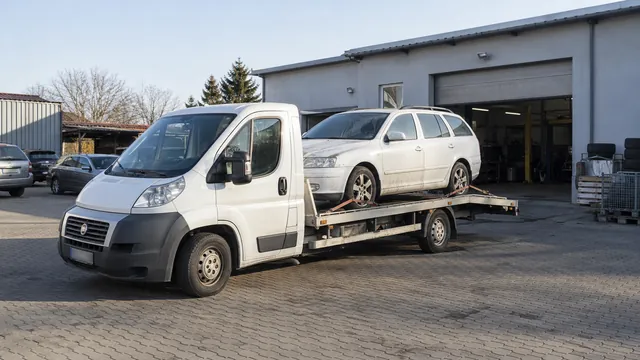 Bílý odtahový vůz s upevněným vozidlem Škoda na hliníkové plošině