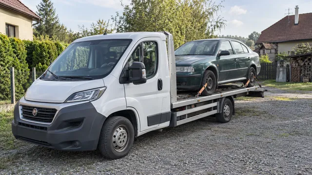 Bílý odtahový vůz s upevněným vozidlem Škoda na hliníkové plošině