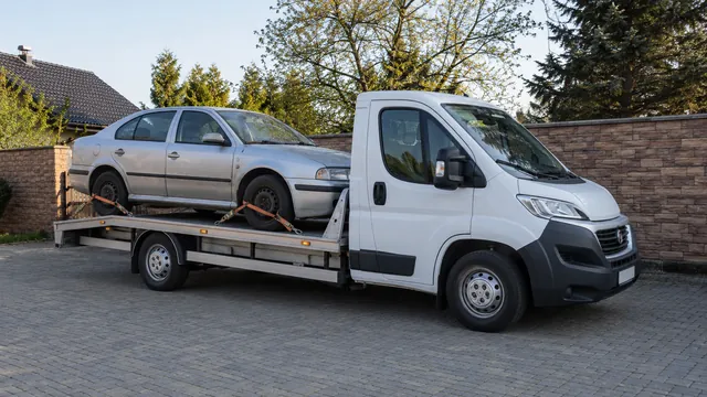 Bílý odtahový vůz s upevněným vozidlem Škoda na hliníkové plošině