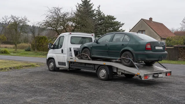 Bílý odtahový vůz s upevněným vozidlem Škoda na hliníkové plošině