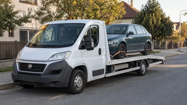 Bílý odtahový vůz s upevněným vozidlem Škoda na hliníkové plošině