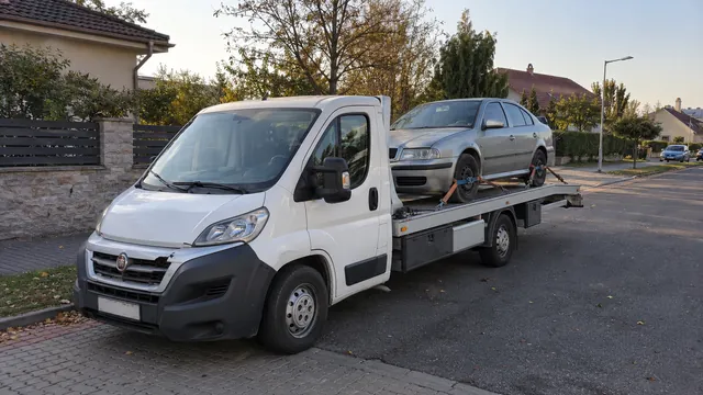 Bílý odtahový vůz s upevněným vozidlem Škoda na hliníkové plošině