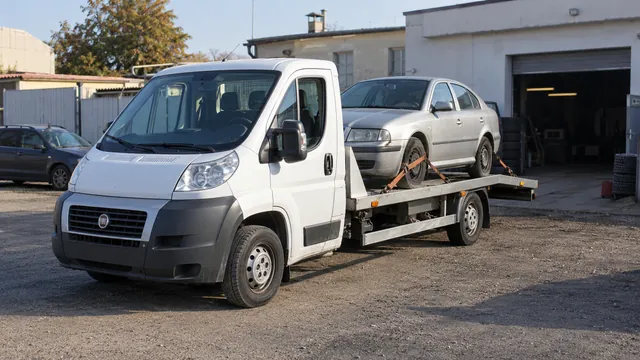 Bílý odtahový vůz s upevněným vozidlem Škoda na hliníkové plošině