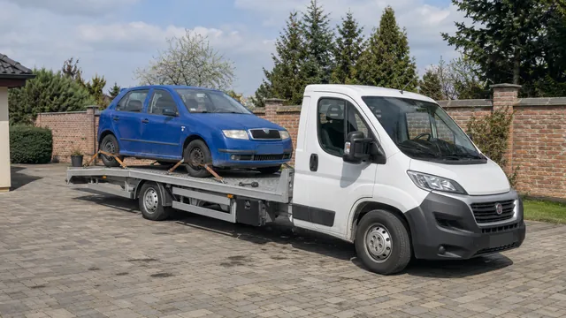 Bílý odtahový vůz s upevněným vozidlem Škoda na hliníkové plošině