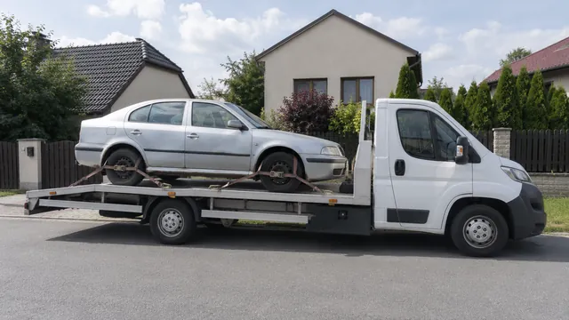 Bílý odtahový vůz s upevněným vozidlem Škoda na hliníkové plošině