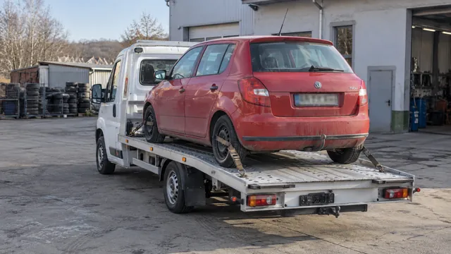 Bílý odtahový vůz s upevněným vozidlem Škoda na hliníkové plošině