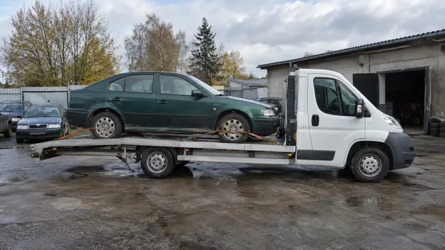 Bílý odtahový vůz s upevněným vozidlem Škoda na hliníkové plošině