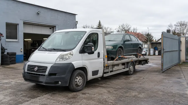 Bílý odtahový vůz s upevněným vozidlem Škoda na hliníkové plošině