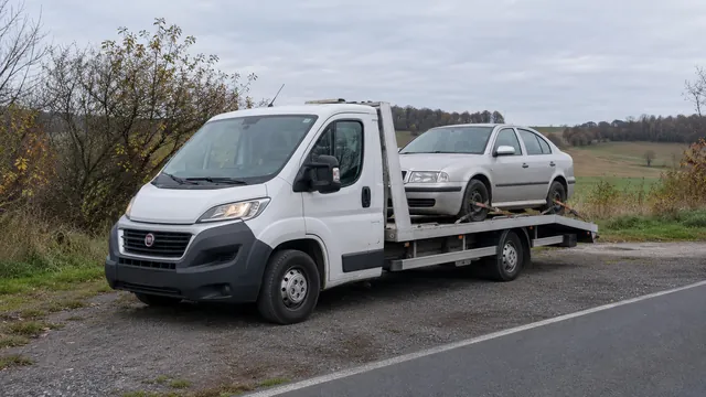 Bílý odtahový vůz s upevněným vozidlem Škoda na hliníkové plošině