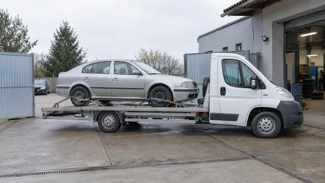 Bílý odtahový vůz s upevněným vozidlem Škoda na hliníkové plošině