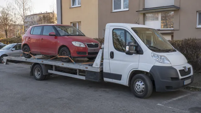 Bílý odtahový vůz s upevněným vozidlem Škoda na hliníkové plošině