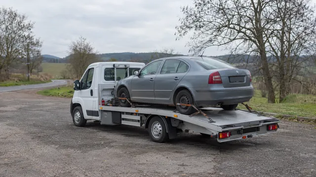 Bílý odtahový vůz s upevněným vozidlem Škoda na hliníkové plošině