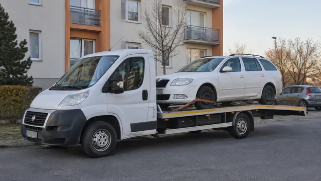 Bílý odtahový vůz s upevněným vozidlem Škoda na hliníkové plošině