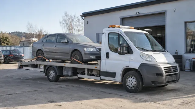 Bílý odtahový vůz s upevněným vozidlem Škoda na hliníkové plošině