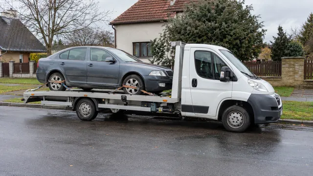 Bílý odtahový vůz s upevněným vozidlem Škoda na hliníkové plošině