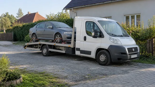 Bílý odtahový vůz s upevněným vozidlem Škoda na hliníkové plošině
