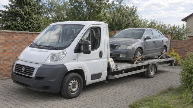 Bílý odtahový vůz s upevněným vozidlem Škoda na hliníkové plošině